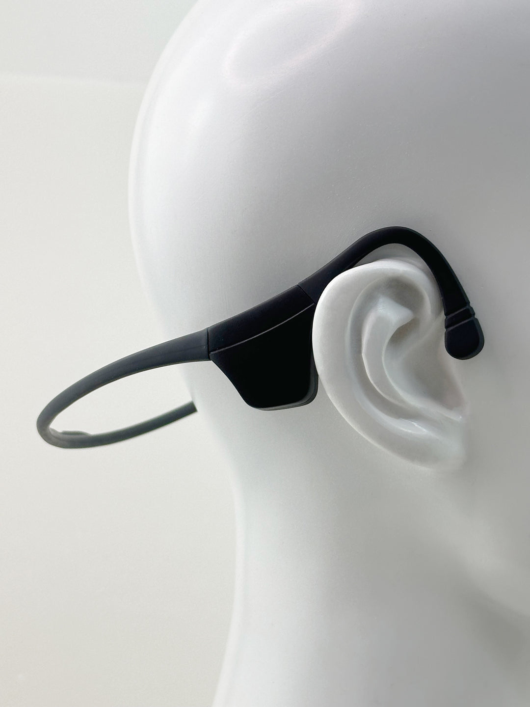 Black LyteFlyte on a mannequin ear with a plain background