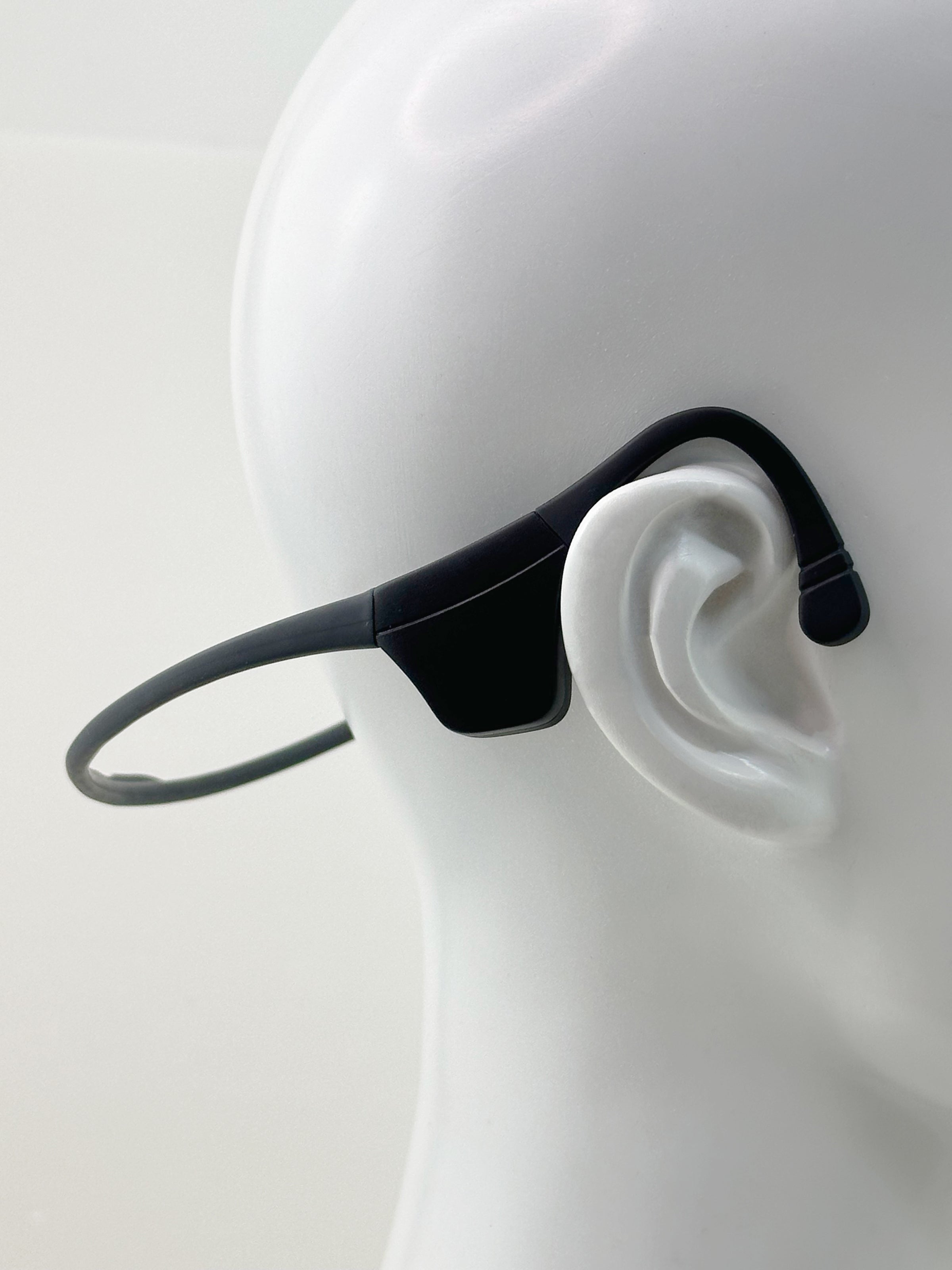 Black LyteFlyte on a mannequin ear with a plain background